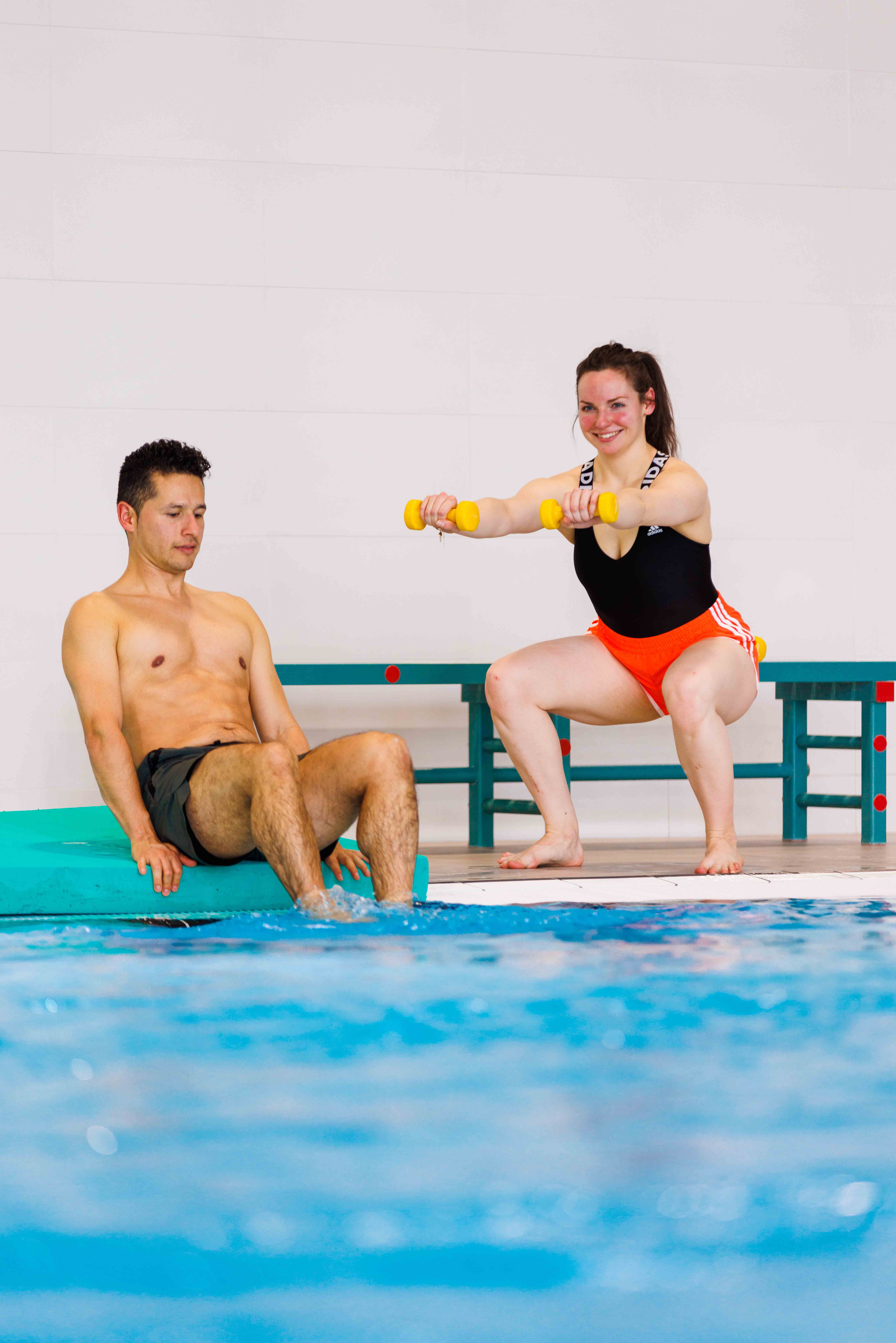 Twee sporters verbeteren hun conditie tijdens een pittige AquaBootcamp les in een zwembad bij Optisport.